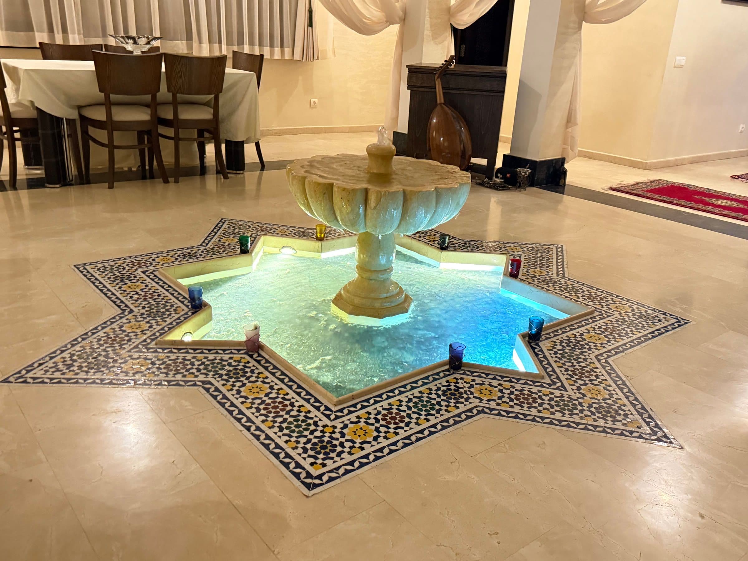 Bassin-fontaine en zellige étoilé dans une salle à manger