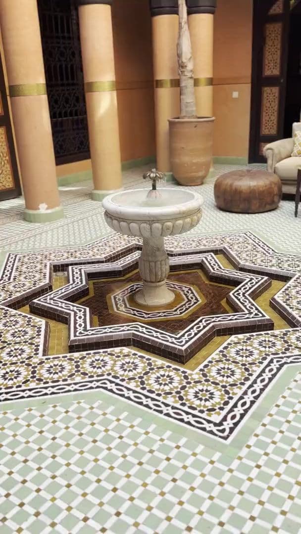 Fontaine de marbre au centre d'un sol en zellige étoilé